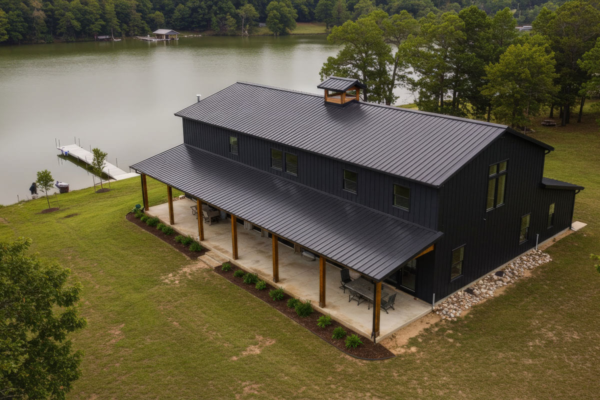 A Barndominium Home With Black Roof And Black Siding At Lakeside